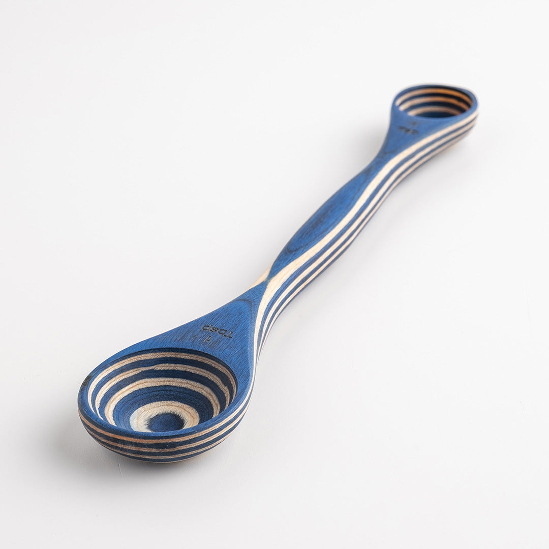 Blue and white striped wooden spoon on a white background