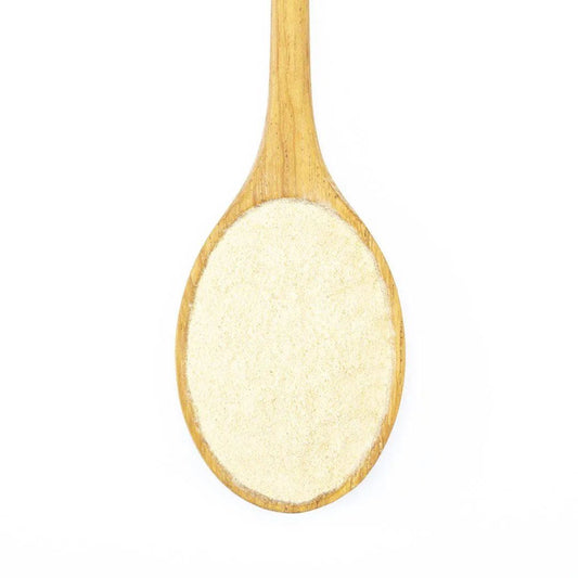 A wooden spoon holds fine, light-colored Organic Peruvian Maca Powder, a renowned adaptogen, displayed on a white background.