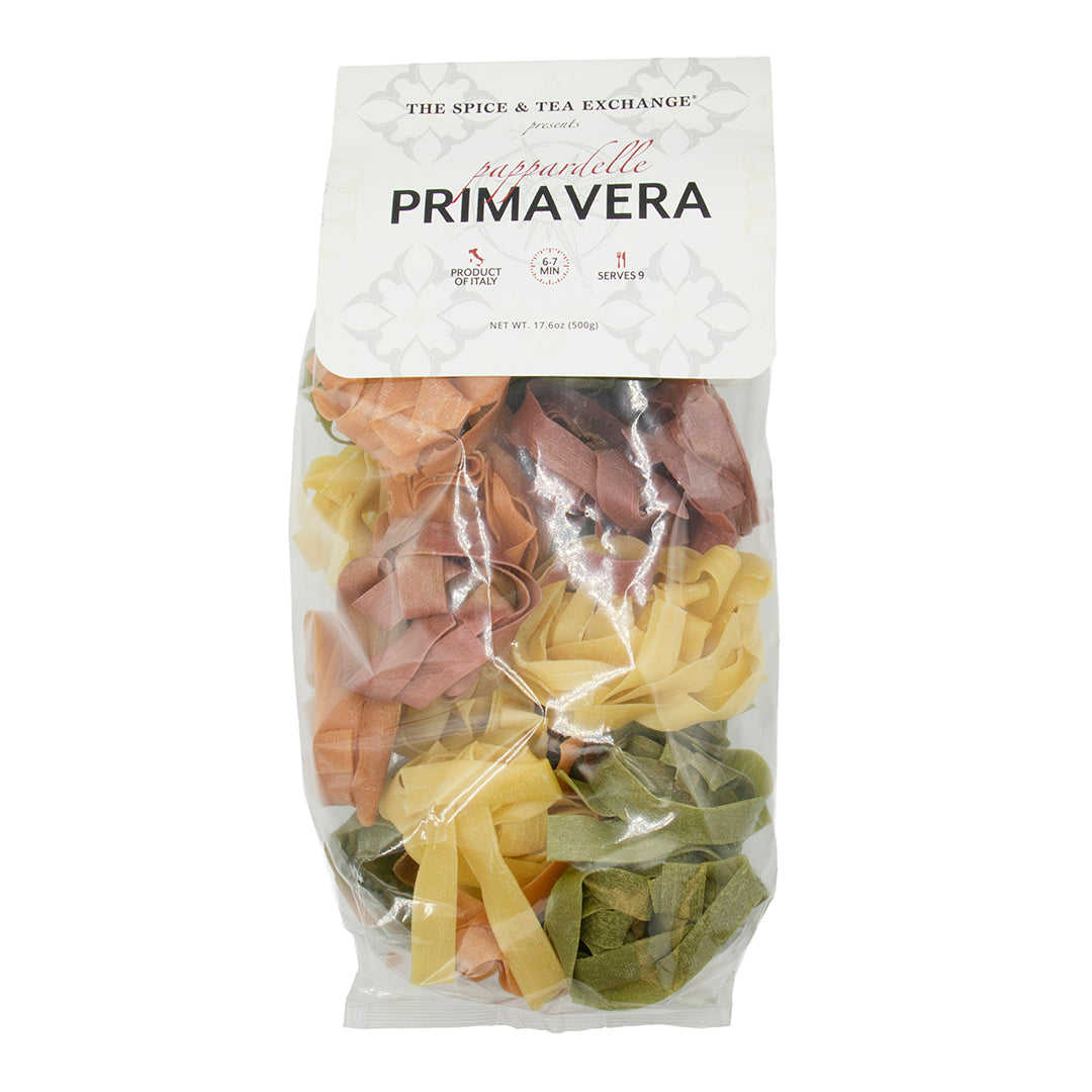 Packaged Pappardelle Primavera with colorful ribbons in a clear bag on a white background