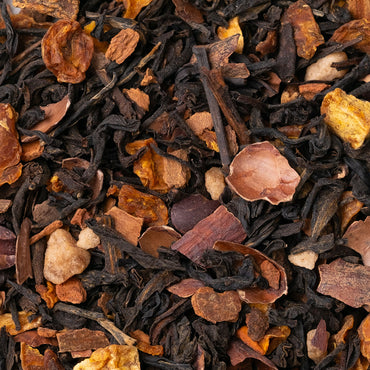 A close-up, top-down view of a loose-leaf tea blend featuring dark brown and black tea leaves mixed with dried orange, yellow, and light brown citrus peel pieces.