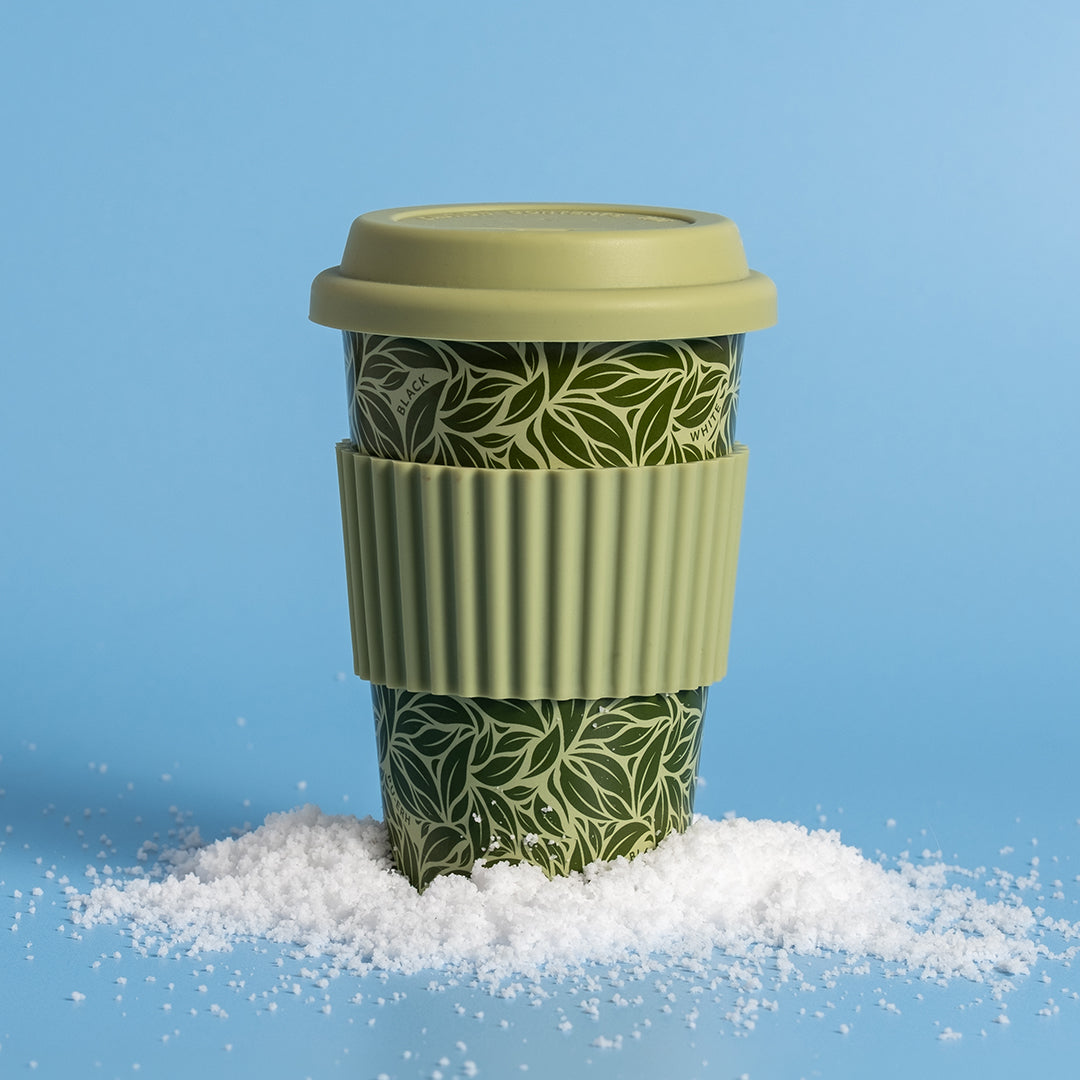 Reusable Hot Cup 12 oz - Tea Leaf Green on blue background in pile of snow