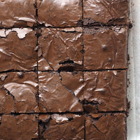 Close-up of brownies cut into squares, their crisp, shiny tops revealing a rich fudgy texture. Made with Roasted Espresso Monk Fruit Sweetener, they have a subtle coffee twist and natural sweetness.