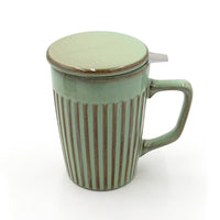 Green ceramic mug with striped design and lid on a white background