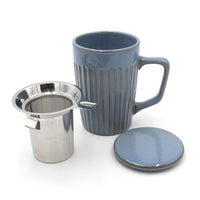 Blue mug with metal tea infuser and matching coaster on a white background
