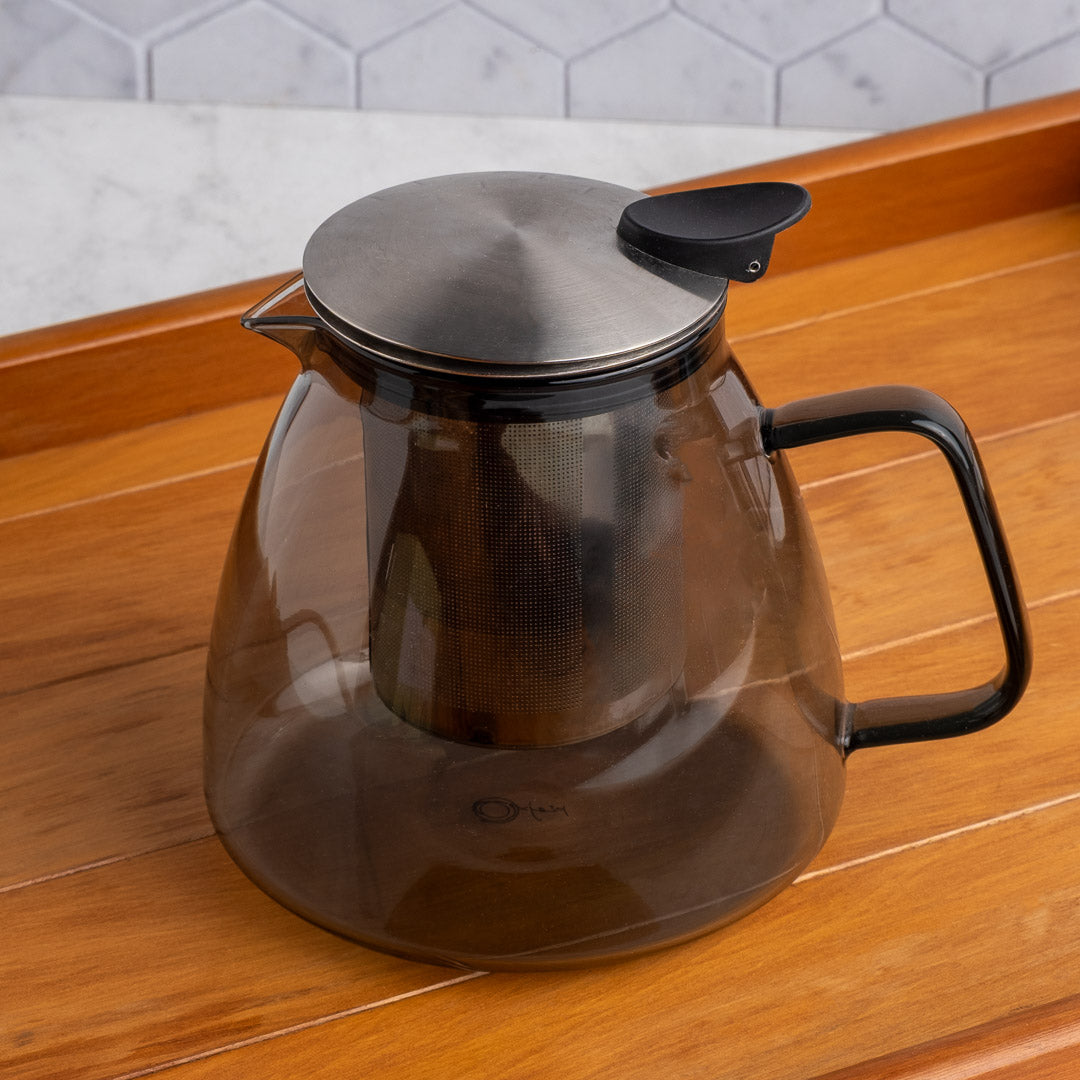 Stormy Glass Teapot with metal lid on a wooden surface