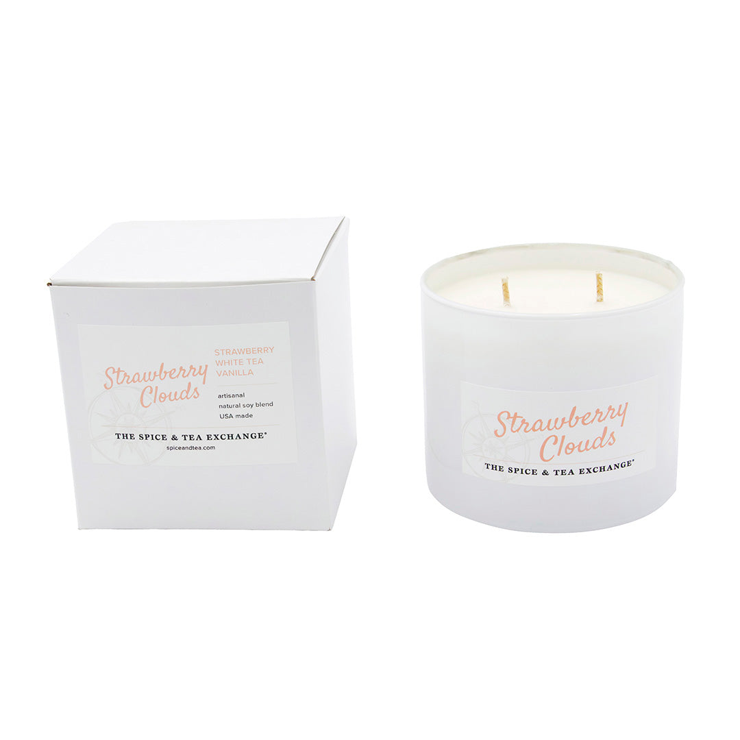 White candle with 'Strawberry Clouds' branding next to its white box on a white background