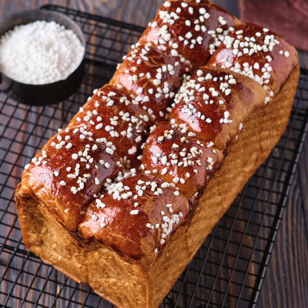 Loaf of bread with sesame seeds on a cooling rack