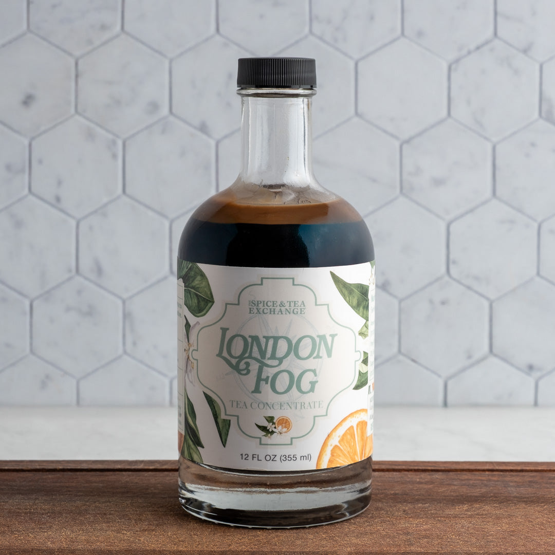 Bottle of 'London Fog' tea concentrate on a wooden surface with a tiled wall background
