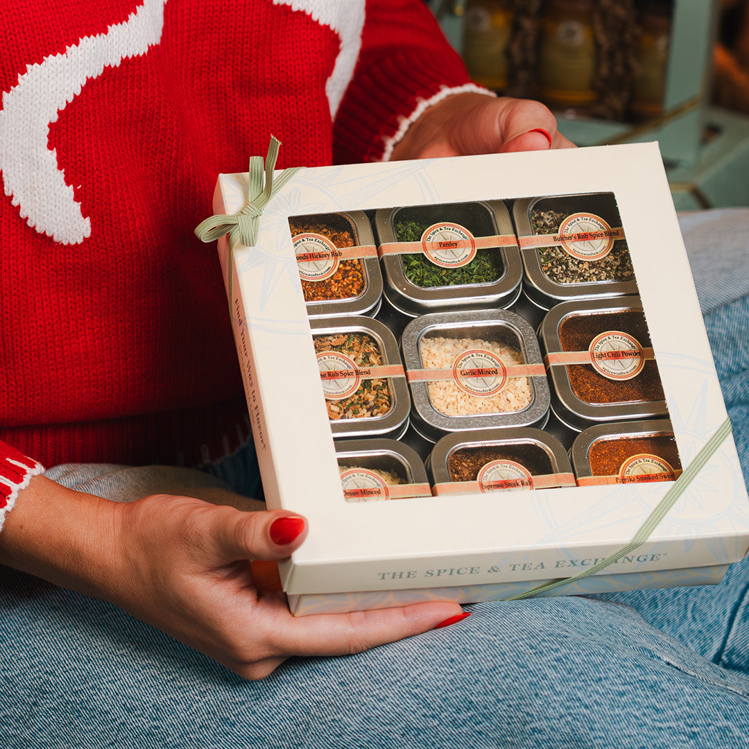 Gift of Grilling 9 Tin Gift Box being held by someone in red sweater and blue jeans