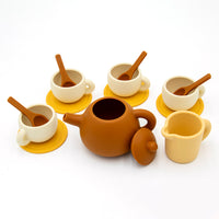 The Tiny Tea Party Toy Set includes a brown teapot with lid, four cream cups with saucers and spoons, and a small creamer—ideal for play kitchen fun and endless pretend tea parties on a white background.