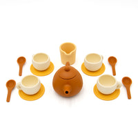The Tiny Tea Party Toy Set includes a brown teapot, four cream cups with yellow saucers, a matching creamer, and four brown spoons—ideal for imaginative play and beautifully displayed on a white background.