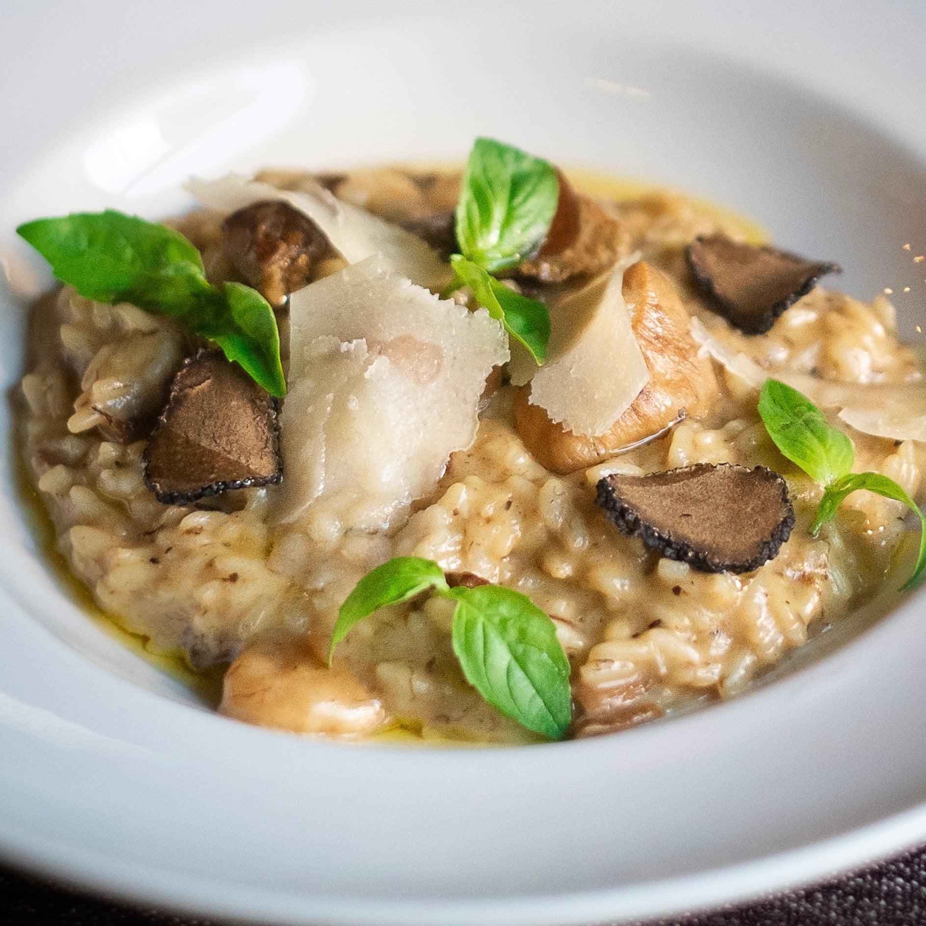 Risotto with mushrooms and basil in a white bowl