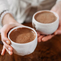 Ultimate Hot Chocolate in white mugs in a hand