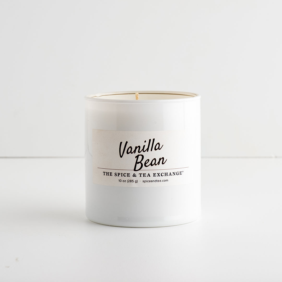 A white glass candle jar labeled 'Vanilla Bean' by The Spice & Tea Exchange, on a white background.