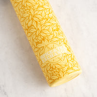 Yellow spice container with leaf pattern on a marble surface